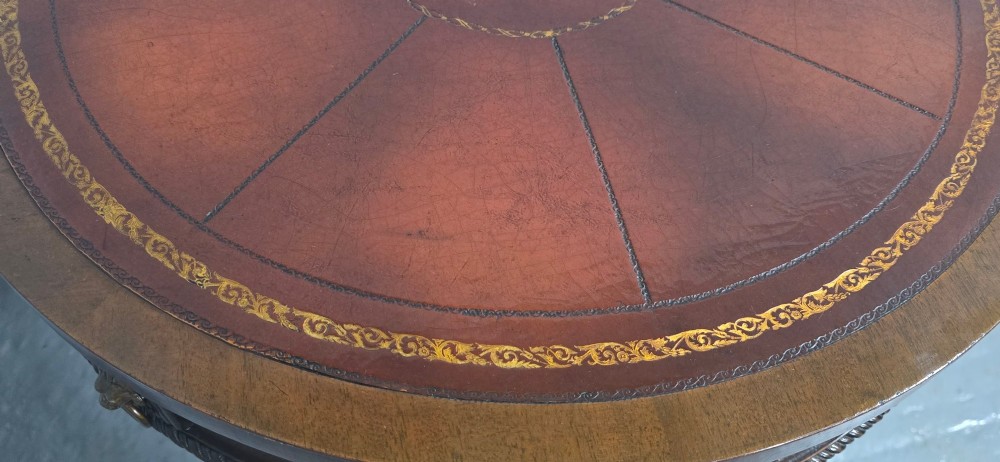 A circular mahogany occasional centre table with a segmented veneered top, brass lion mask handle, and curved reeded legs. View XII
