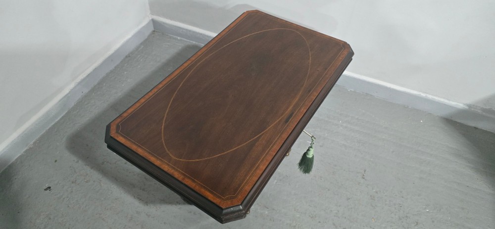 A tapered sarcophagus-shaped dark mahogany wine cooler featuring satinwood line inlay, brass lion paw feet, and a central keyhole with a green tassel. View XII