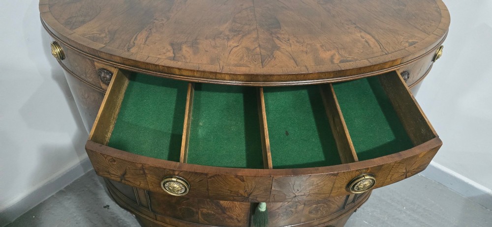 A semi-circular burr yew wood side cabinet featuring brass mounts along the frieze and central double doors. View XI
