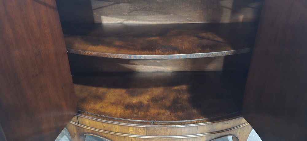 A semi-circular burr yew wood side cabinet featuring brass mounts along the frieze and central double doors. View XIV