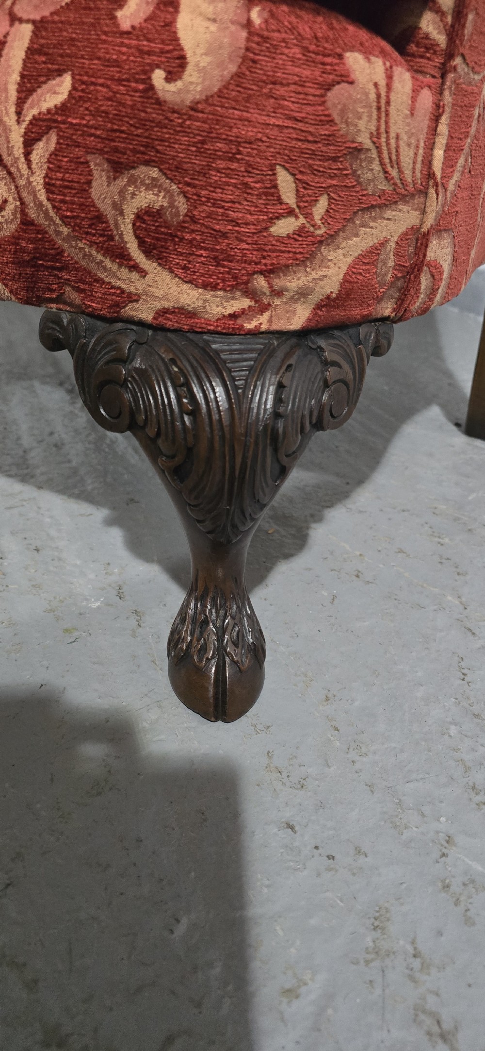 A high-backed wing armchair upholstered in red floral damask fabric with carved mahogany cabriole front legs featuring claw and ball feet. View IV