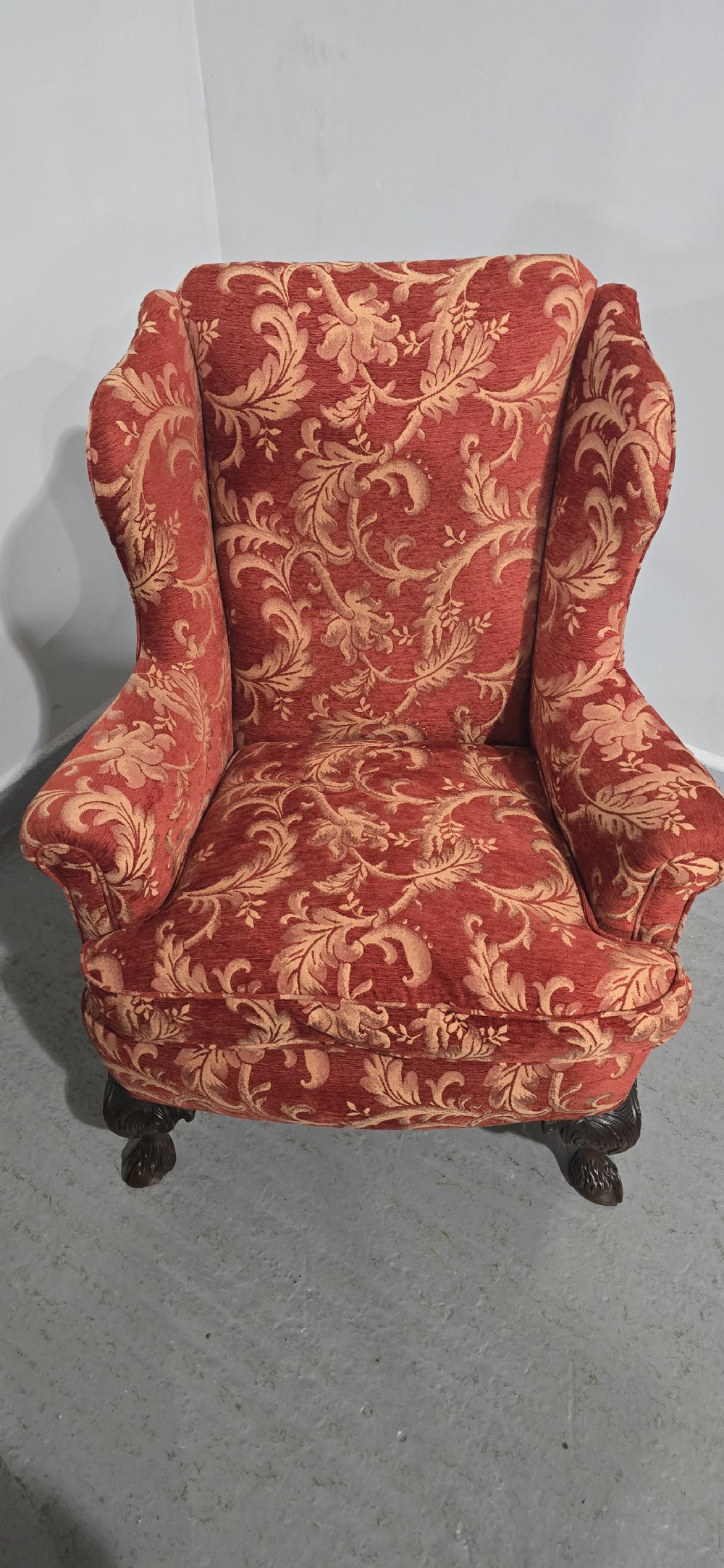 A high-backed wing armchair upholstered in red floral damask fabric with carved mahogany cabriole front legs featuring claw and ball feet. View VIII