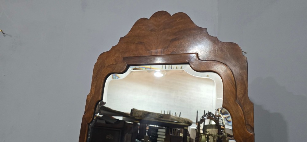 A standing Queen Anne style burr walnut cheval mirror featuring a shaped crest, tilting glass plate, finial-topped uprights, and cabriole legs. View VI