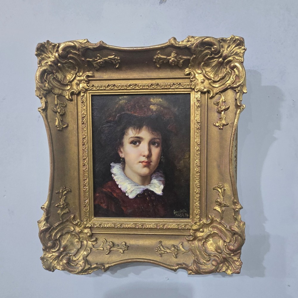 An oil painting on board depicting a young woman with dark hair and a ruffled white collar, displayed within a heavily carved gold Rococo style frame. View II