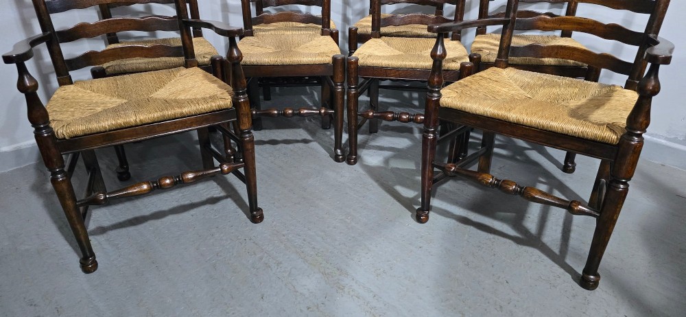 A set of eight dark oak ladder back dining chairs featuring woven rush seats, curved back rungs, and turned front legs with stretchers. View VII