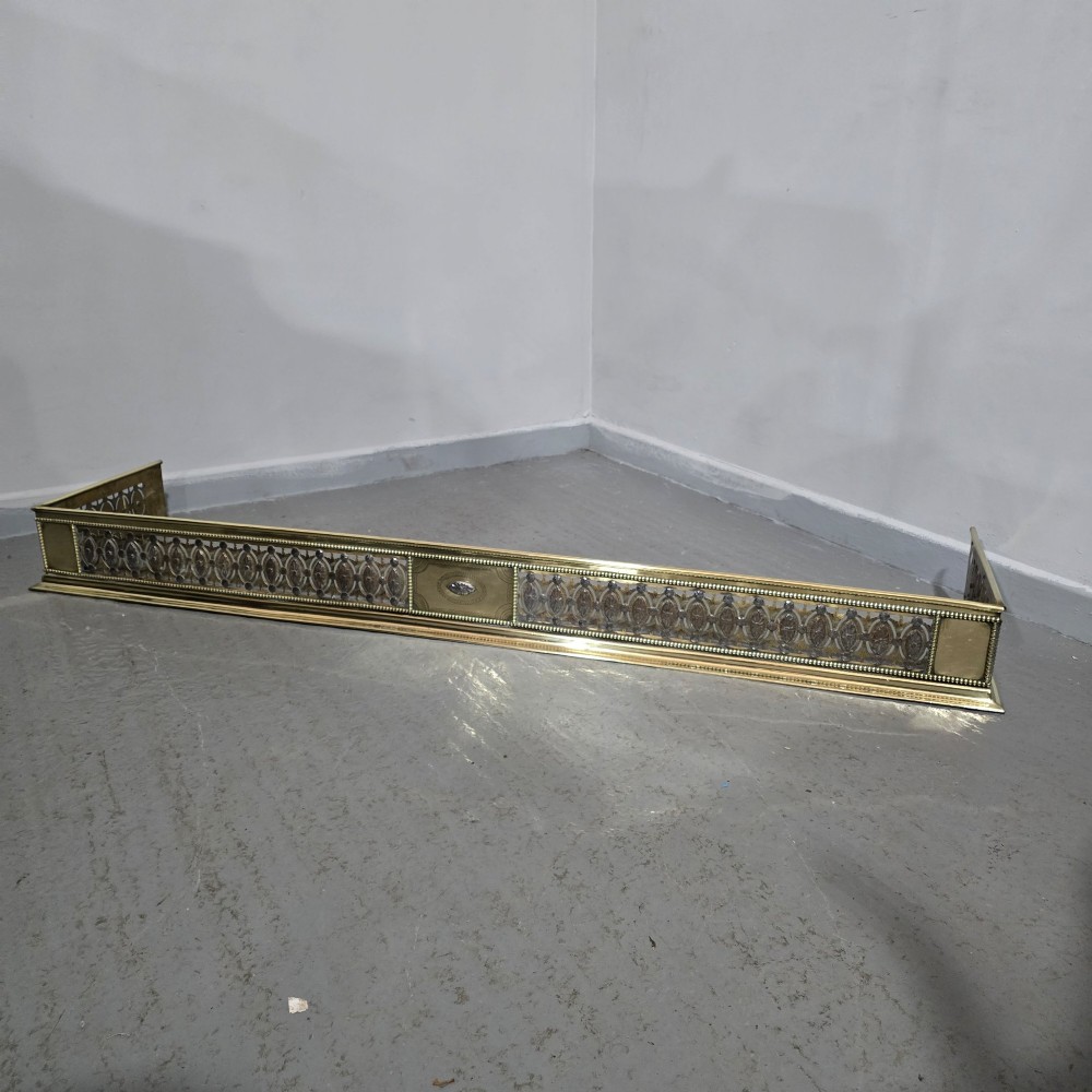 A wide Georgian brass and pierced cut steel fireplace fender with decorative geometric patterns and beaded borders. View II