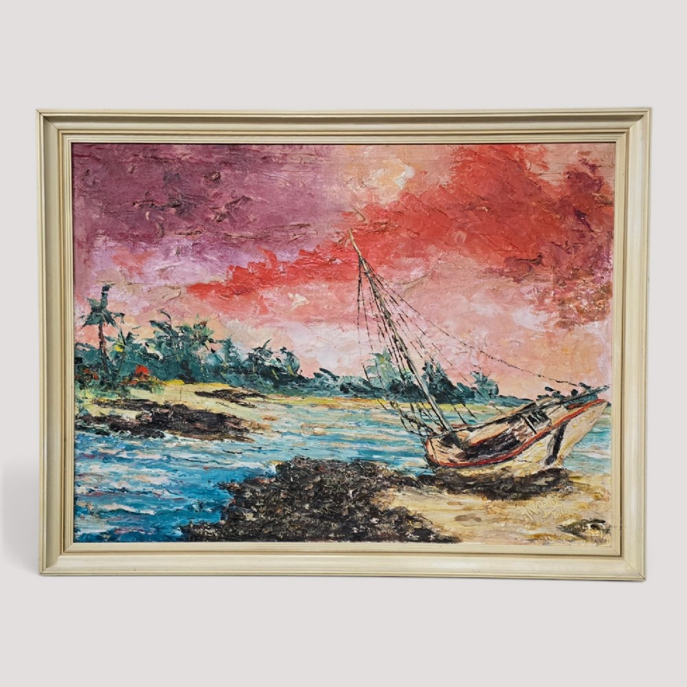 A framed impasto oil painting depicting a sailboat on a beach shoreline under a vibrant pink and red sky.