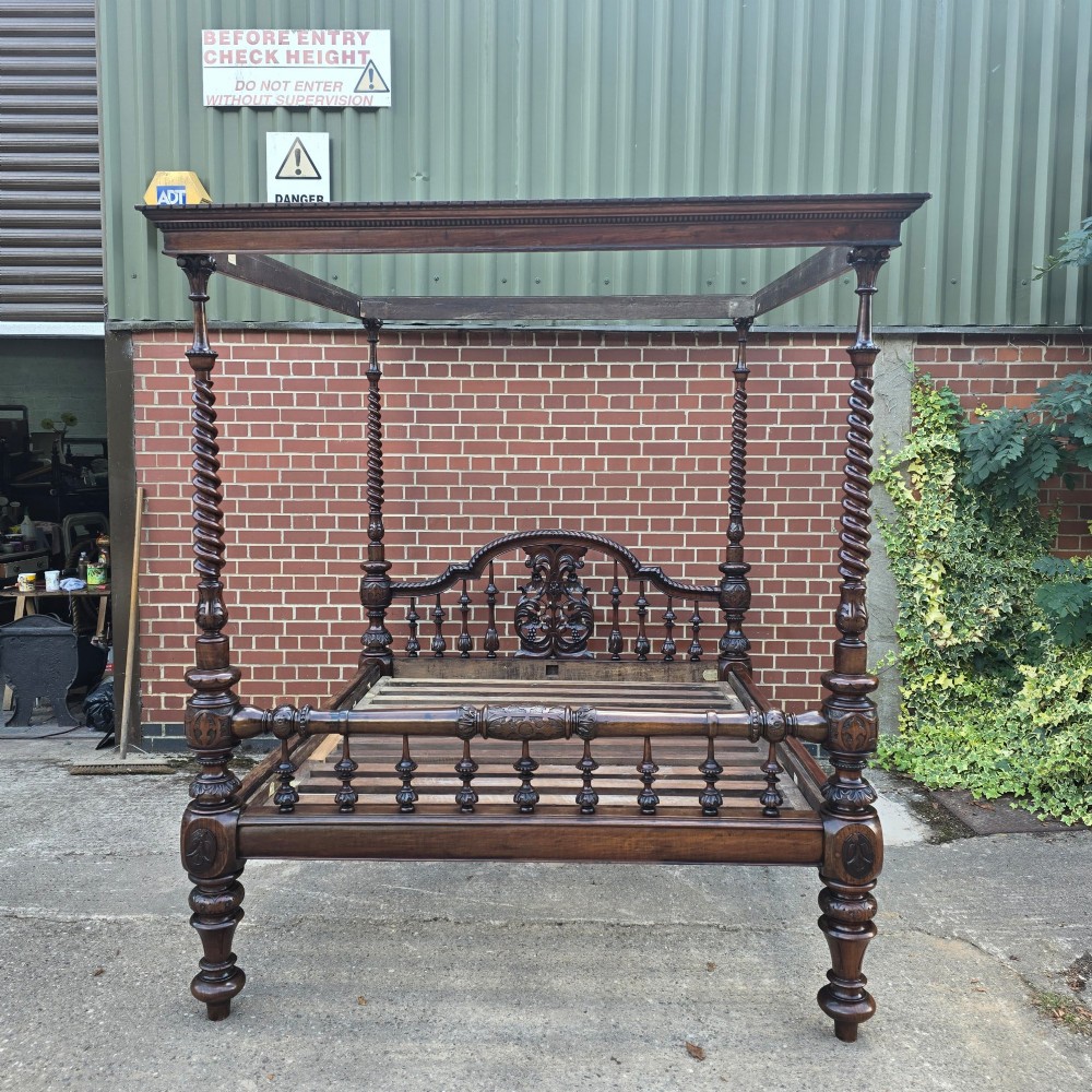 A dark wood four-poster bed frame featuring carved spiral posts, turned spindles, and an arched cresting headboard. View XI