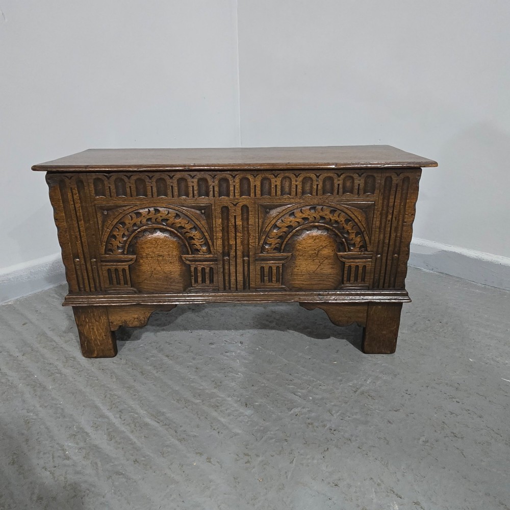 A miniature dark oak coffer featuring carved double arches on the front panel and a hinged rectangular lid. View V
