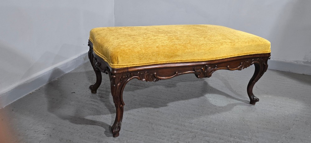 A rectangular Regency period stool featuring a mustard yellow fabric top resting on a dark carved rosewood frame with cabriole legs. View VI