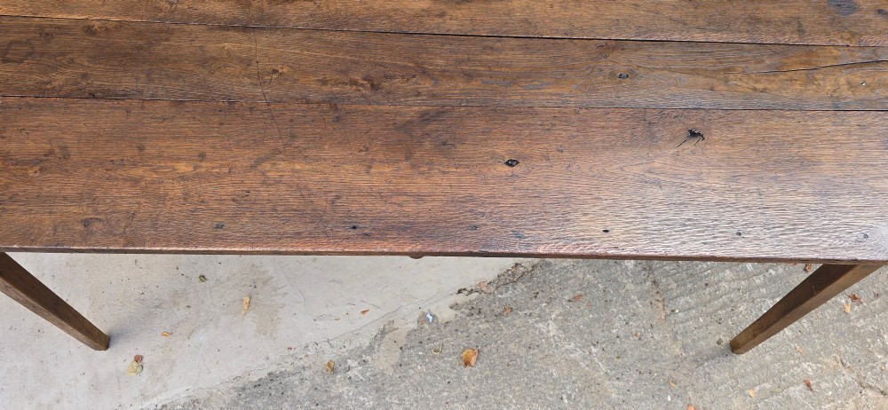 An antique rustic French wooden refectory dining table featuring a three-plank top, single side drawer, and square tapered legs. View XIV