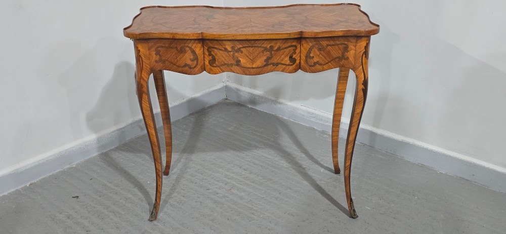 A small French Louis XV style writing table crafted from warm brown wood with scrolling marquetry, a serpentine edge, and slim cabriole legs. View XII