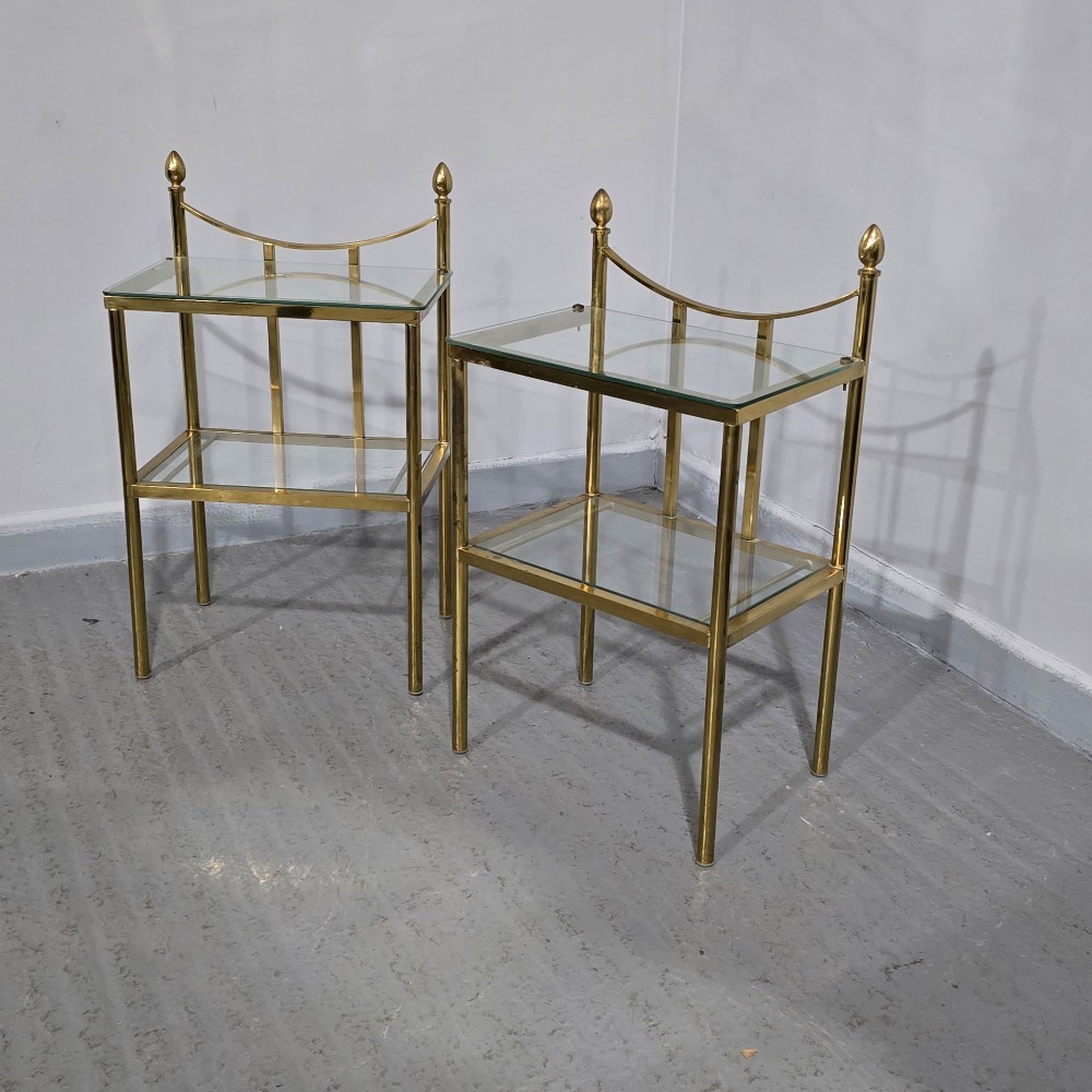 Pair of two-tier brass side tables with clear glass shelves and decorative finials. View III
