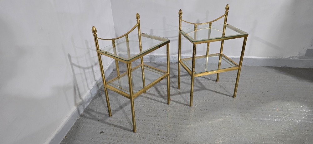 Pair of two-tier brass side tables with clear glass shelves and decorative finials. View V