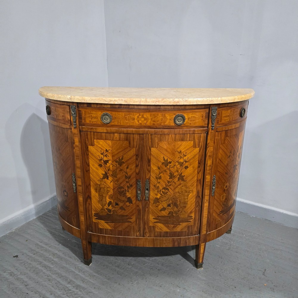 A French Louis XVI style demi-lune cabinet featuring intricate floral marquetry inlay, gilt-bronze mounts, and a contoured marble top. View II