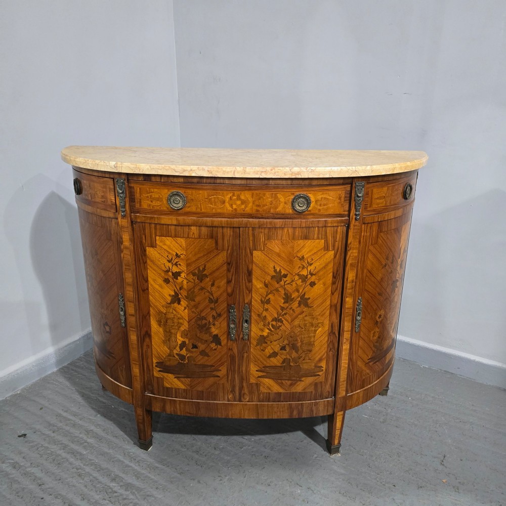 A French Louis XVI style demi-lune cabinet featuring intricate floral marquetry inlay, gilt-bronze mounts, and a contoured marble top. View III
