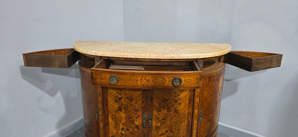 A French Louis XVI style demi-lune cabinet featuring intricate floral marquetry inlay, gilt-bronze mounts, and a contoured marble top. View VIII