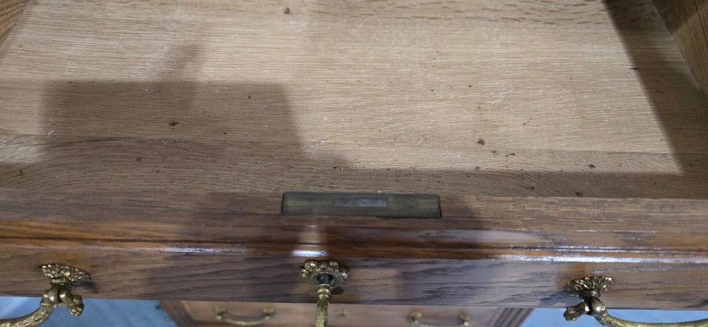 A tall French oak chest of drawers featuring six stacked drawers, brass swing handles, fluted side pilasters, and turned wooden feet. View XI