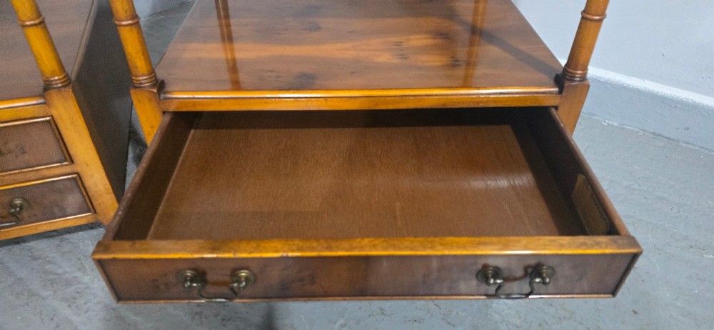 A pair of yew wood lamp tables featuring dark green leather inset tops, a middle shelf, two drawers with brass handles, and turned corner columns. View V