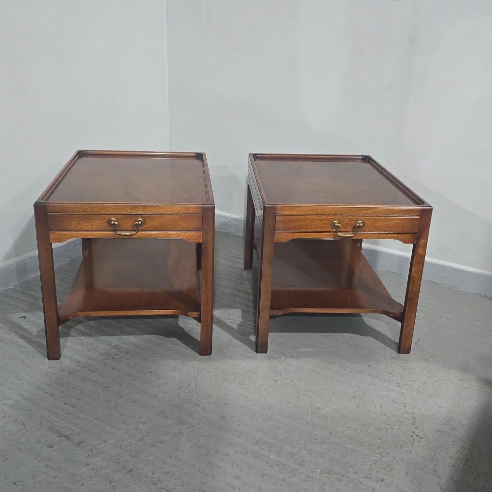 A pair of solid mahogany lamp end tables featuring tray tops, single drawers with brass handles, and lower tier shelves. View II