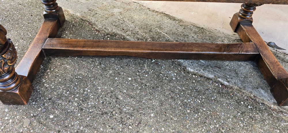 A heavy dark oak refectory dining table featuring carved cup-and-cover bulbous legs and a low stretcher base. View VI