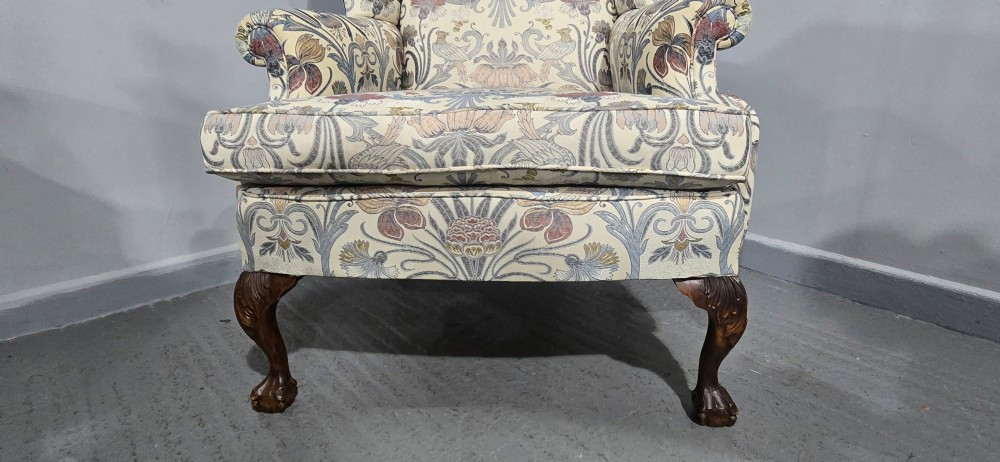 A high-backed wingback armchair upholstered in a botanical pattern with dark carved cabriole legs and ball-and-claw feet. View II