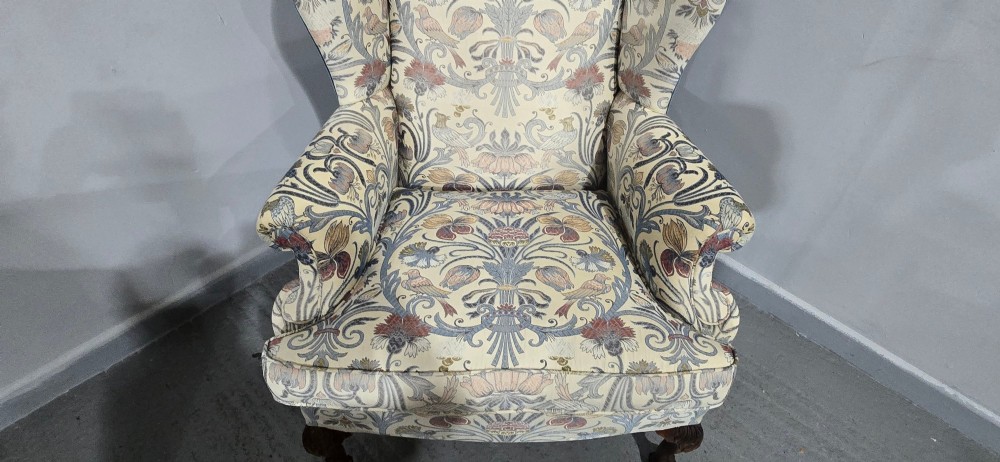 A high-backed wingback armchair upholstered in a botanical pattern with dark carved cabriole legs and ball-and-claw feet. View III