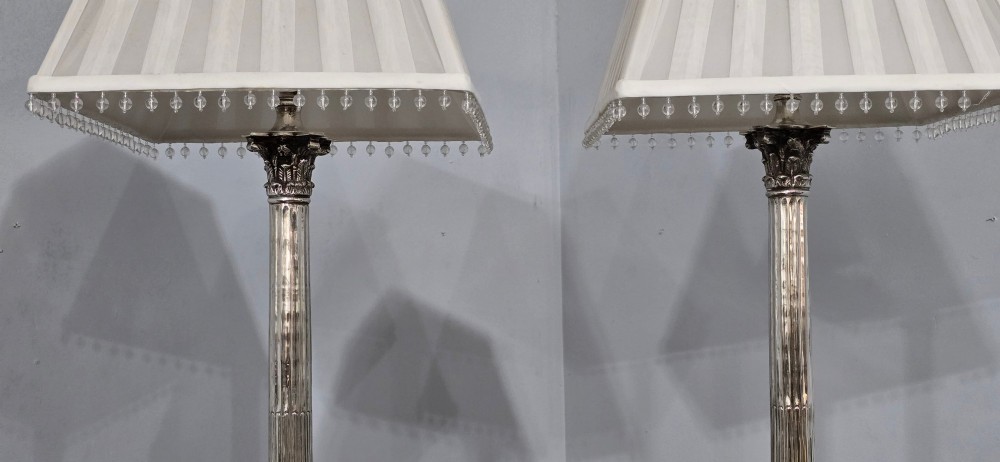 A pair of silver-plated neoclassical column table lamps with square stepped plinths and white pleated shades featuring beaded lower trim. View V