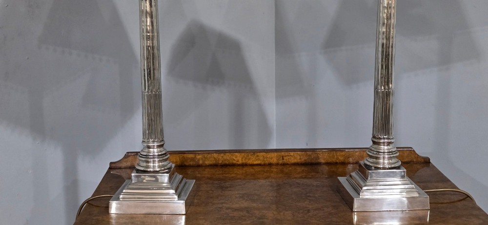 A pair of silver-plated neoclassical column table lamps with square stepped plinths and white pleated shades featuring beaded lower trim. View VI