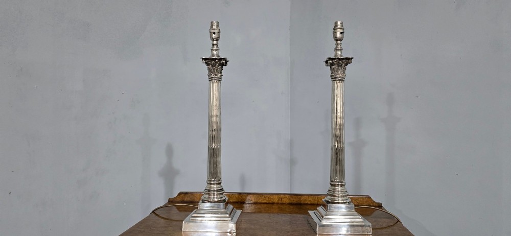 A pair of silver-plated neoclassical column table lamps with square stepped plinths and white pleated shades featuring beaded lower trim. View VIII