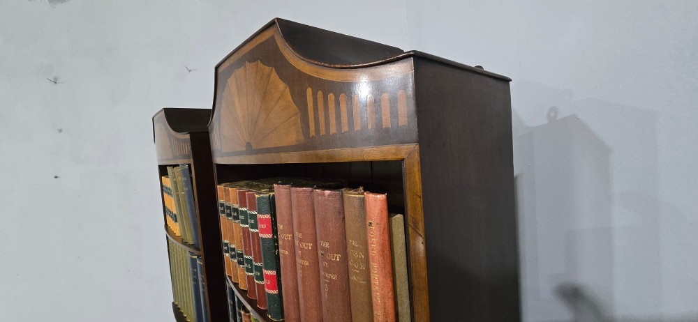 A pair of tall slim mahogany open bookcases featuring inlaid fan pediments, adjustable shelves, and curved lower cupboard doors. View IX
