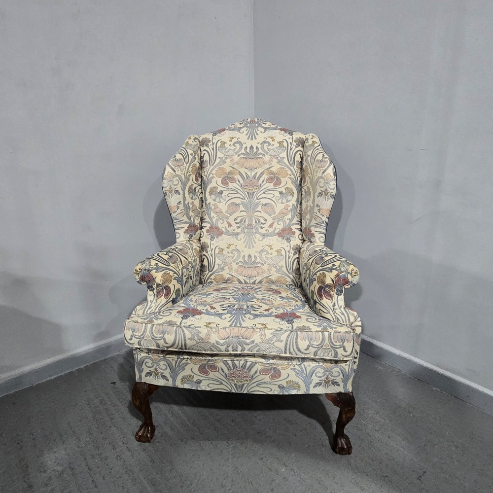 A high-backed wing armchair upholstered in a botanical pattern fabric featuring dark mahogany cabriole front legs with carved ball and claw feet. View II
