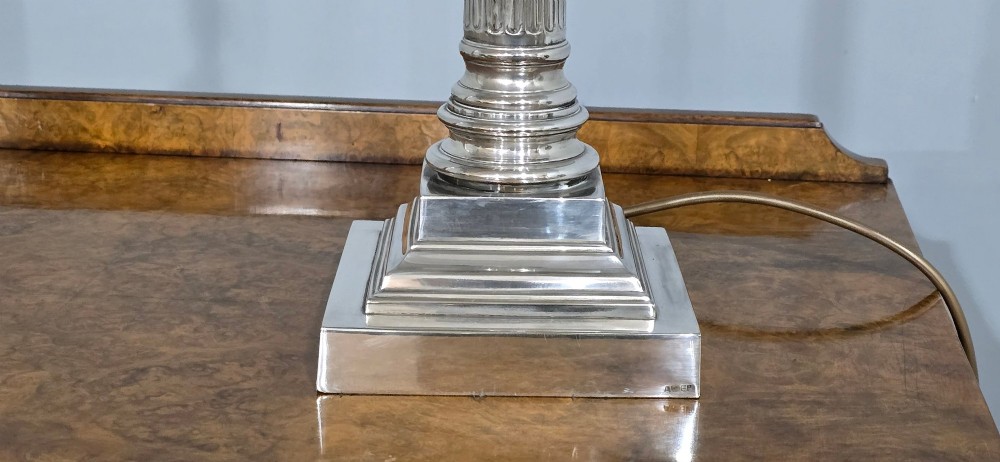 A pair of silver-plated table lamps styled as fluted Corinthian columns on stepped square bases, fitted with white pleated shades with beaded trim. View V