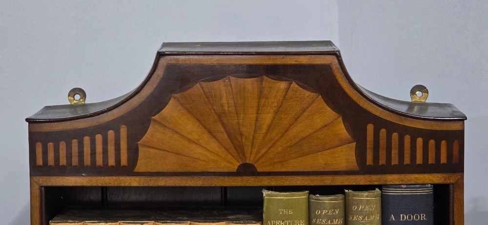 A pair of tall, narrow mahogany open bookcases featuring inlaid fan motifs at the arched top, adjustable shelves filled with books, and lower cupboard doors. View IV
