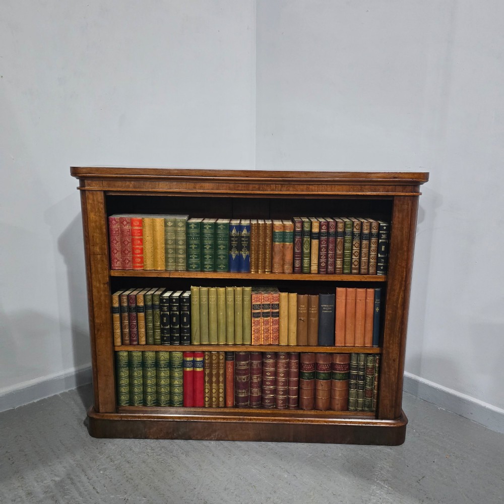 A solid mahogany Victorian open bookcase featuring adjustable internal shelves and a solid plinth base filled with books. View II