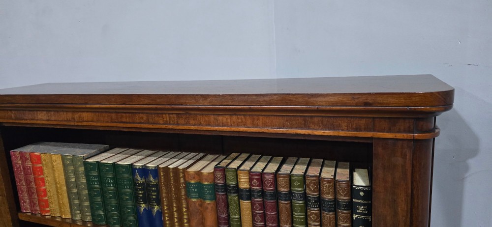 A solid mahogany Victorian open bookcase featuring adjustable internal shelves and a solid plinth base filled with books. View VI