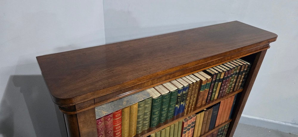 A solid mahogany Victorian open bookcase featuring adjustable internal shelves and a solid plinth base filled with books. View XII