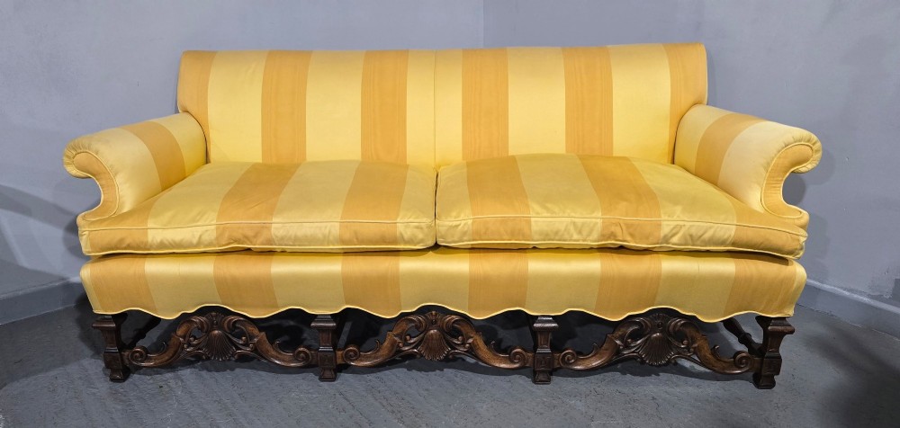 An upholstered sofa featuring yellow and gold vertical stripes with an intricately carved dark oak base decorated with shell motifs and scrolls. View II