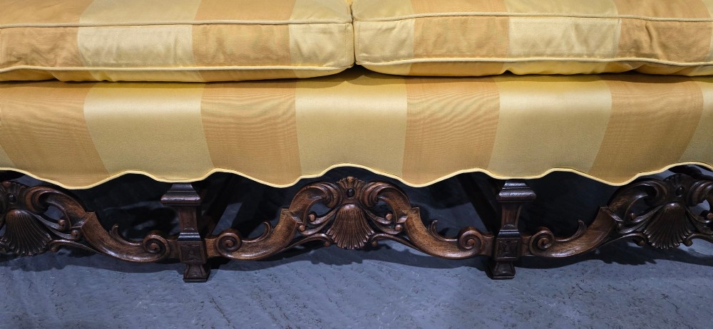 An upholstered sofa featuring yellow and gold vertical stripes with an intricately carved dark oak base decorated with shell motifs and scrolls. View IV