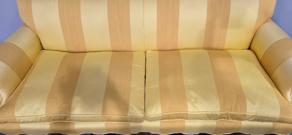 An upholstered sofa featuring yellow and gold vertical stripes with an intricately carved dark oak base decorated with shell motifs and scrolls. View VII