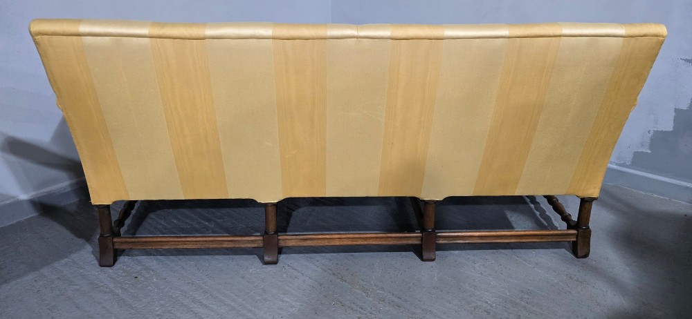 An upholstered sofa featuring yellow and gold vertical stripes with an intricately carved dark oak base decorated with shell motifs and scrolls. View XI