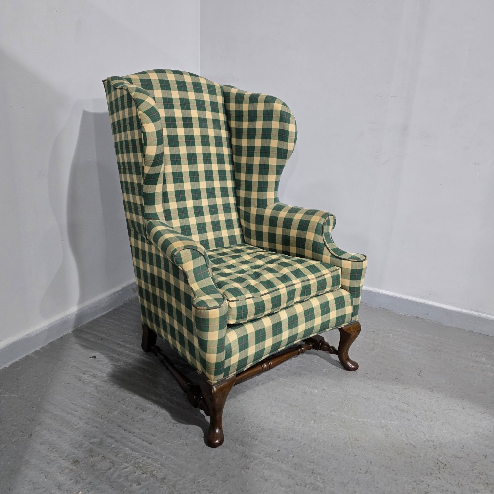 High-backed wingback armchair upholstered in green and cream check fabric with carved oak cabriole front legs. View II