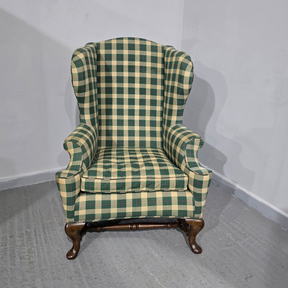 High-backed wingback armchair upholstered in green and cream check fabric with carved oak cabriole front legs. View III