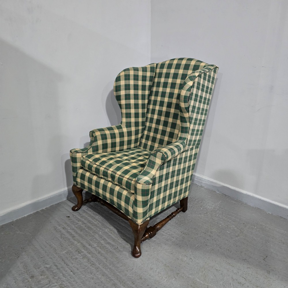 High-backed wingback armchair upholstered in green and cream check fabric with carved oak cabriole front legs. View IV
