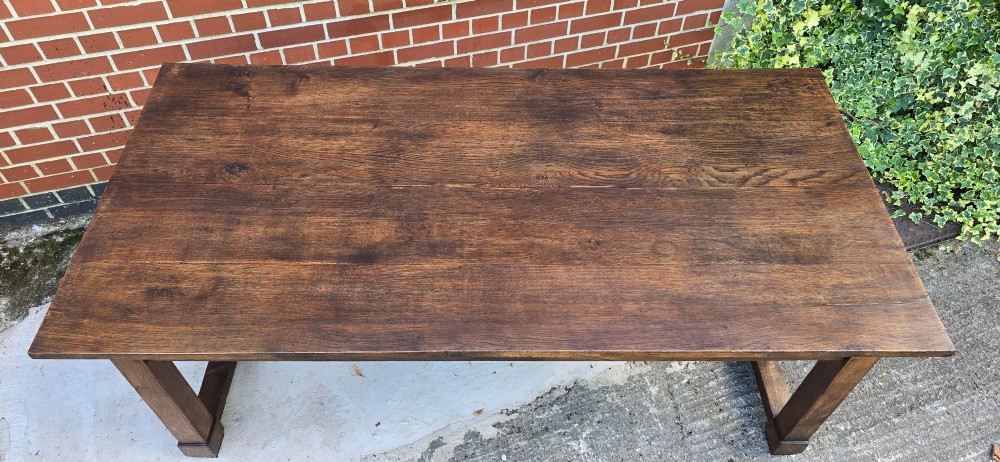 A solid warm brown French oak refectory dining table featuring a rectangular plank top, square legs, and an H-stretcher base. View XII