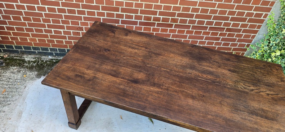 A solid warm brown French oak refectory dining table featuring a rectangular plank top, square legs, and an H-stretcher base. View XIII
