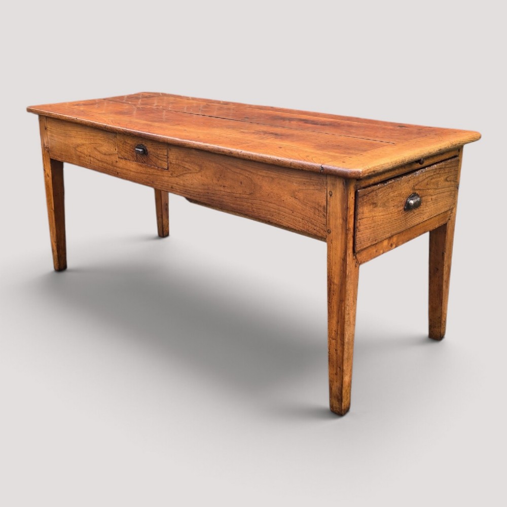 A rectangular French cherry wood refectory dining table featuring a three-plank top, side frieze drawer with metal handle, and square tapered legs.