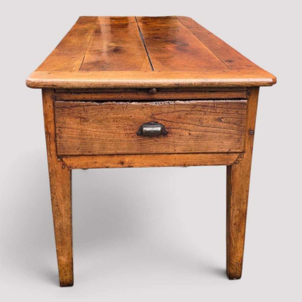 A rectangular French cherry wood refectory dining table featuring a three-plank top, side frieze drawer with metal handle, and square tapered legs. View III