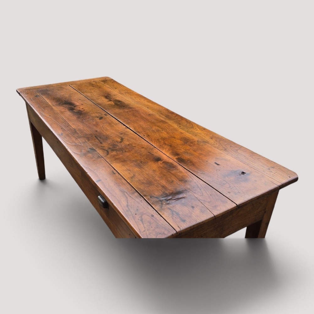 A rectangular French cherry wood refectory dining table featuring a three-plank top, side frieze drawer with metal handle, and square tapered legs. View VIII