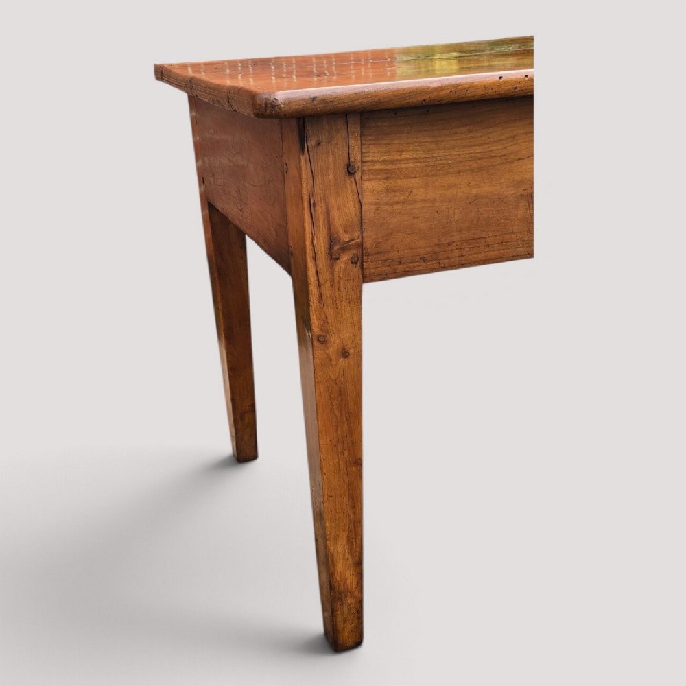 A rectangular French cherry wood refectory dining table featuring a three-plank top, side frieze drawer with metal handle, and square tapered legs. View XI